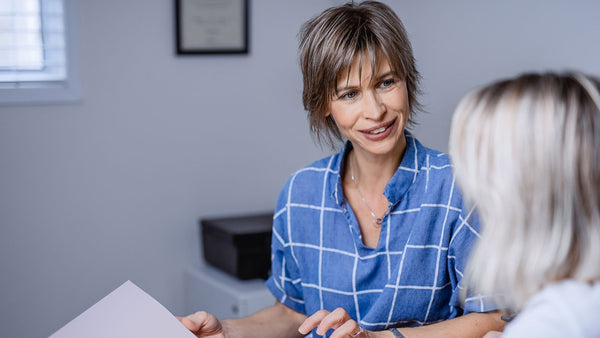 two women chatting indoors