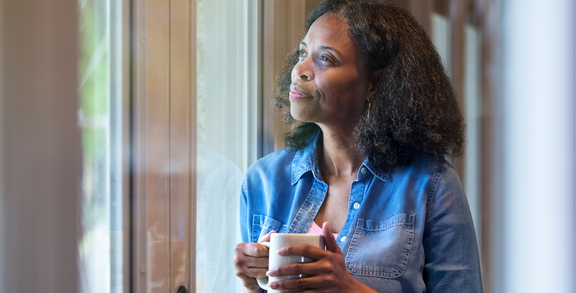 Reflective mature women gazes out of window