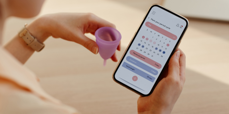 women holding menstrual cup and tracking her period